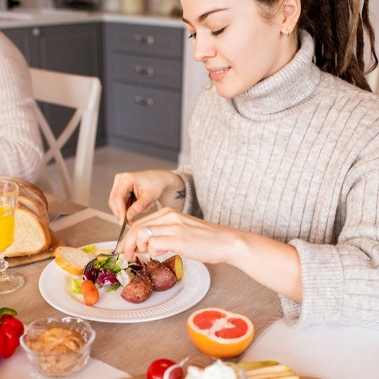 Frau am Tisch mit ausgewogenem Frühstück