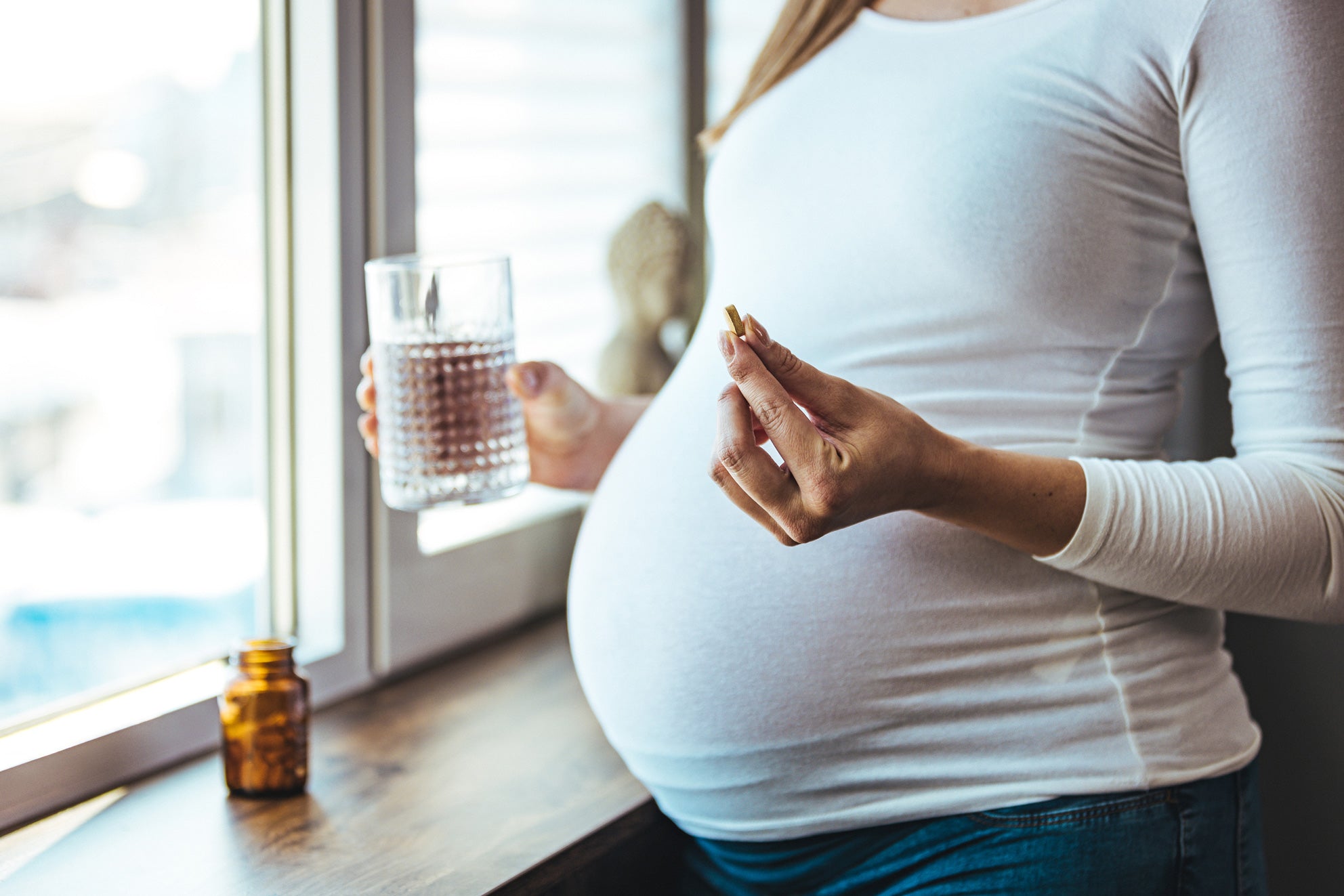 Schwangere Frau nimmt Tabletten ein